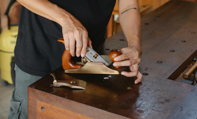 a person cutting a piece of wood with a planer, inspired by Paul Howard Manship, pexels contest winner, arts and crafts movement, brass beak, victor horta, back arched, tabletop model