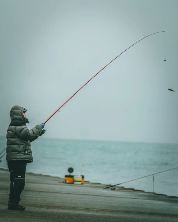 a person standing on a pier with a fishing rod, attacking, iceland photography, trending photo, grey