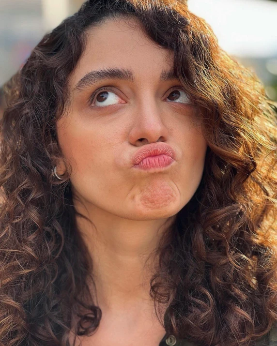 a woman with curly hair sticking out her tongue, trending on pexels, happening, “uwu the prismatic person, big chin, lovely kiss, looking confused