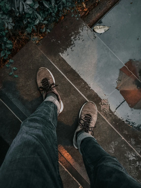 a person standing on a sidewalk with an umbrella, inspired by Elsa Bleda, unsplash contest winner, realism, blue jeans and grey sneakers, sitting in a reflective pool, selfie shot straight on angle, instagram story