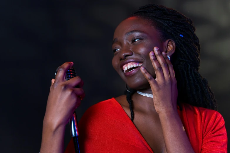 a woman in a red shirt holding a microphone, pexels contest winner, happening, dark skinned, disco smile, avatar image, hand on cheek