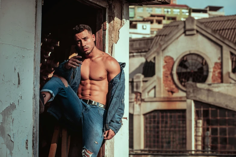 a shirtless man leaning against a building, pexels contest winner, ripped jeans, brazilan supermodel, mohamed chahin, non binary model