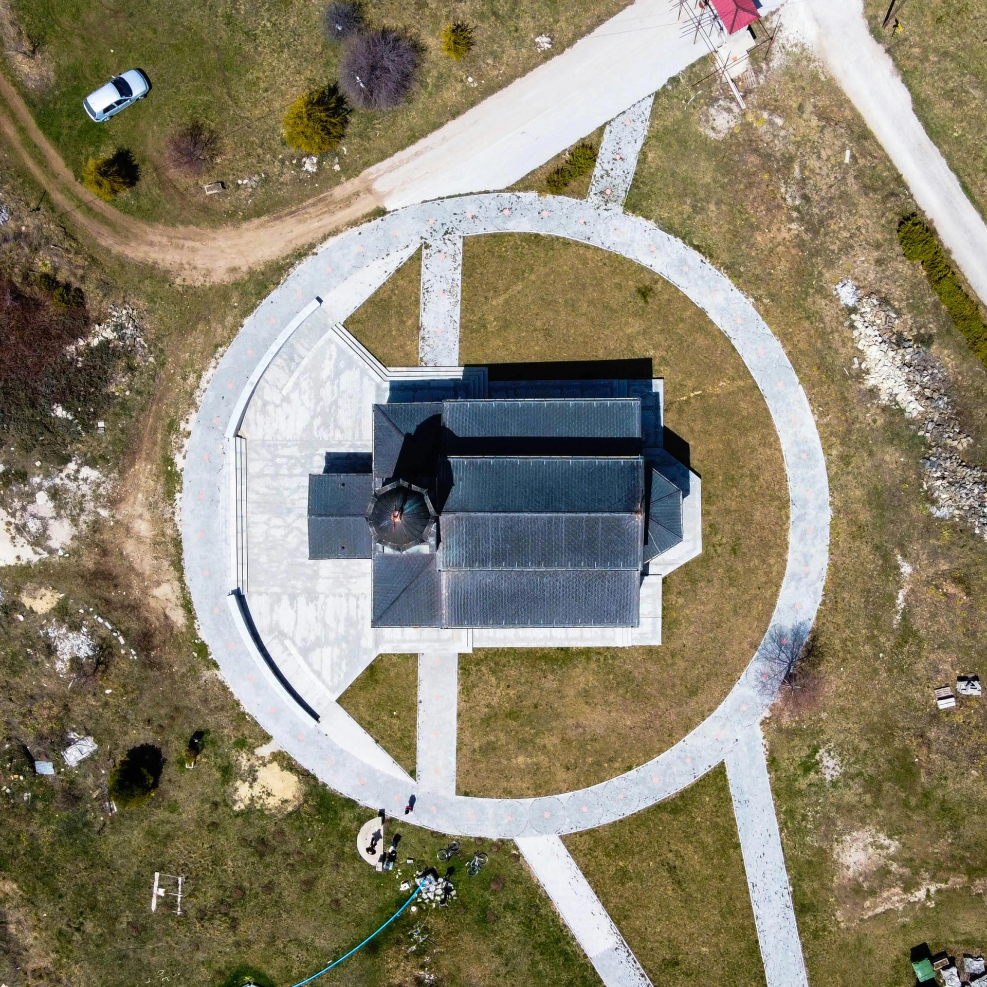 an aerial view of a church in the middle of a field, an album cover, by Attila Meszlenyi, pexels contest winner, land art, rounded roof, sundial, black, 15081959 21121991 01012000 4k