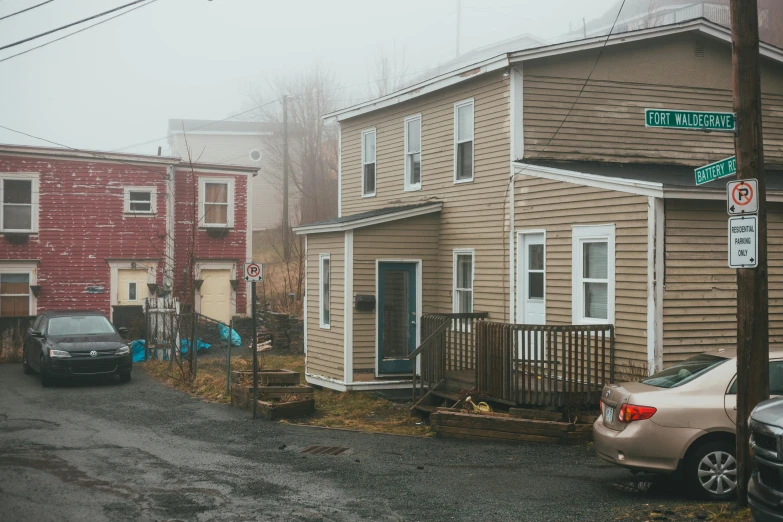 a couple of cars parked on the side of a road, by Carey Morris, pexels contest winner, stacked houses, hazy and dreary, new england architecture, standing in township street