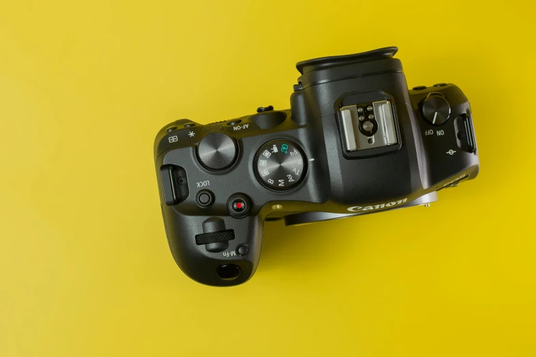 a camera sitting on top of a yellow surface, a picture, canon eos r 6, controller, 1/400 shutterspeed, 6 4 megapixels