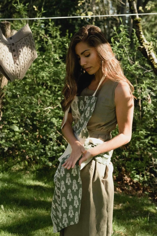 a woman standing next to an elephant on a lush green field, renaissance, blacksmith apron, emma bridgewater and paperchase, olive green, hero shot