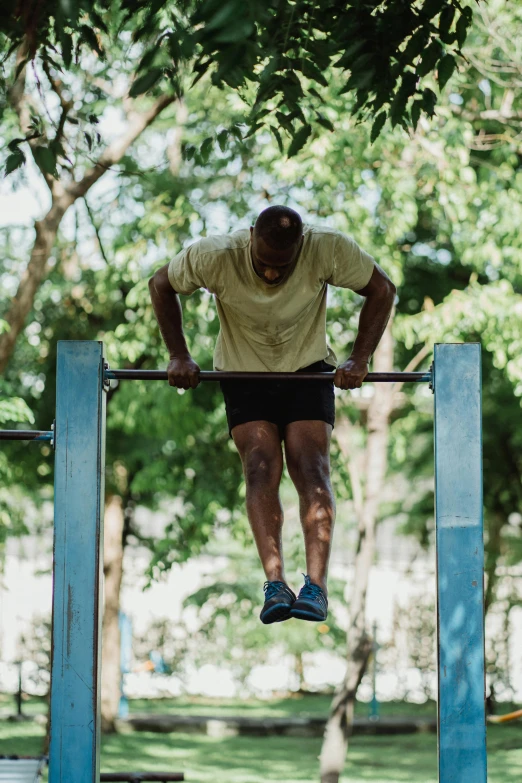 a man on a pull up bar in a park, pexels contest winner, cuba, square, sri lanka, in a gym