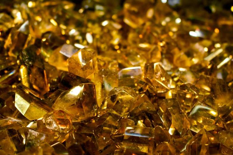 a pile of golden crystals sitting on top of a table, an album cover, pexels, glass texture, amber, brazil, in 2 0 1 5