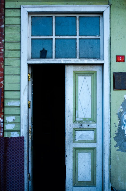 a cat is sitting in the doorway of a building, by Sven Erixson, award winning color photo, square, new orleans, pareidolia