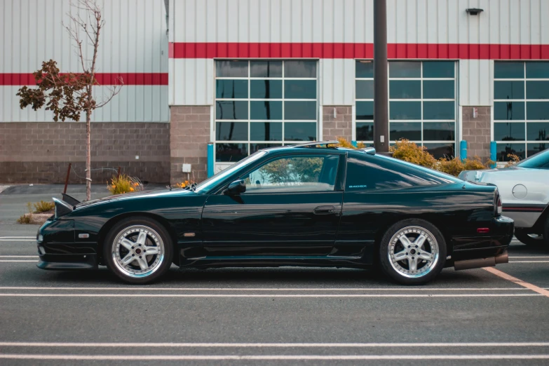 a black sports car parked in front of a building, a portrait, unsplash, 1990's photo, full body profile, fan favorite, teal