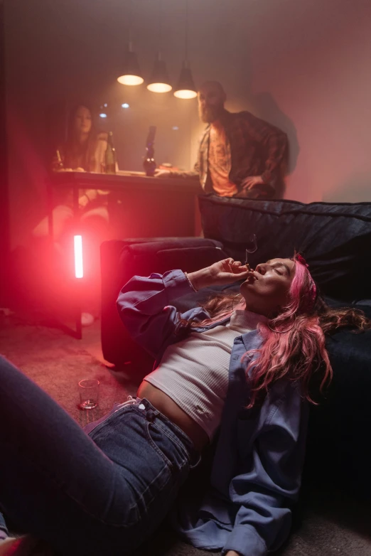 a woman laying on the floor in a living room, inspired by Nan Goldin, trending on pexels, at a rave, smoking a blunt, pink lighting, lil peep