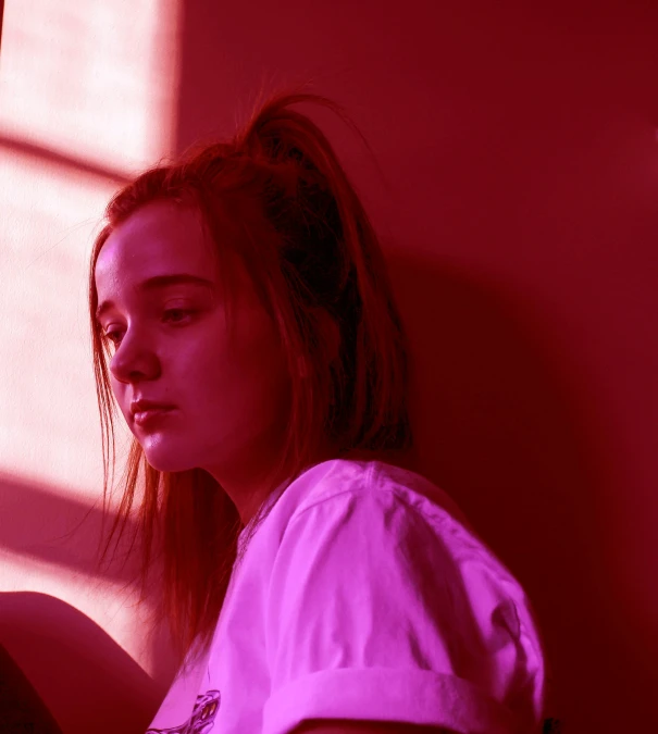 a woman sitting in front of a window reading a book, an album cover, inspired by Elsa Bleda, pexels contest winner, glowing magenta face, volumetric lighting. red, portrait of depressed teen, joey king