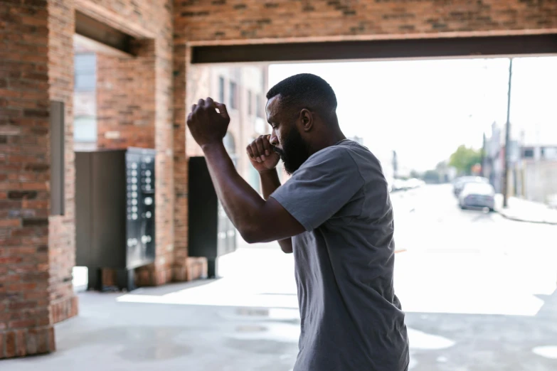 a man taking a picture with his cell phone, by Carey Morris, pexels contest winner, happening, boxing stance, in front of a garage, jaylen brown, bearded and built