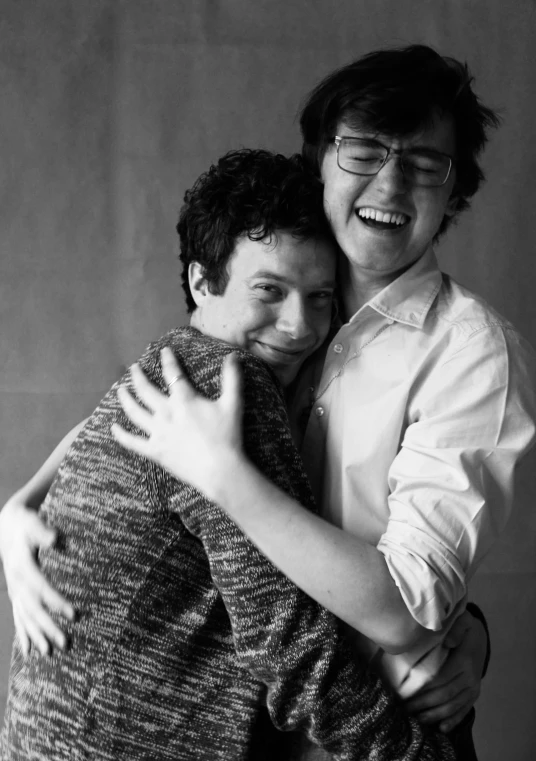 a black and white photo of two men hugging each other, a picture, by Felix-Kelly, joe keery, cute slightly nerdy smile, john egbert, in a photo studio