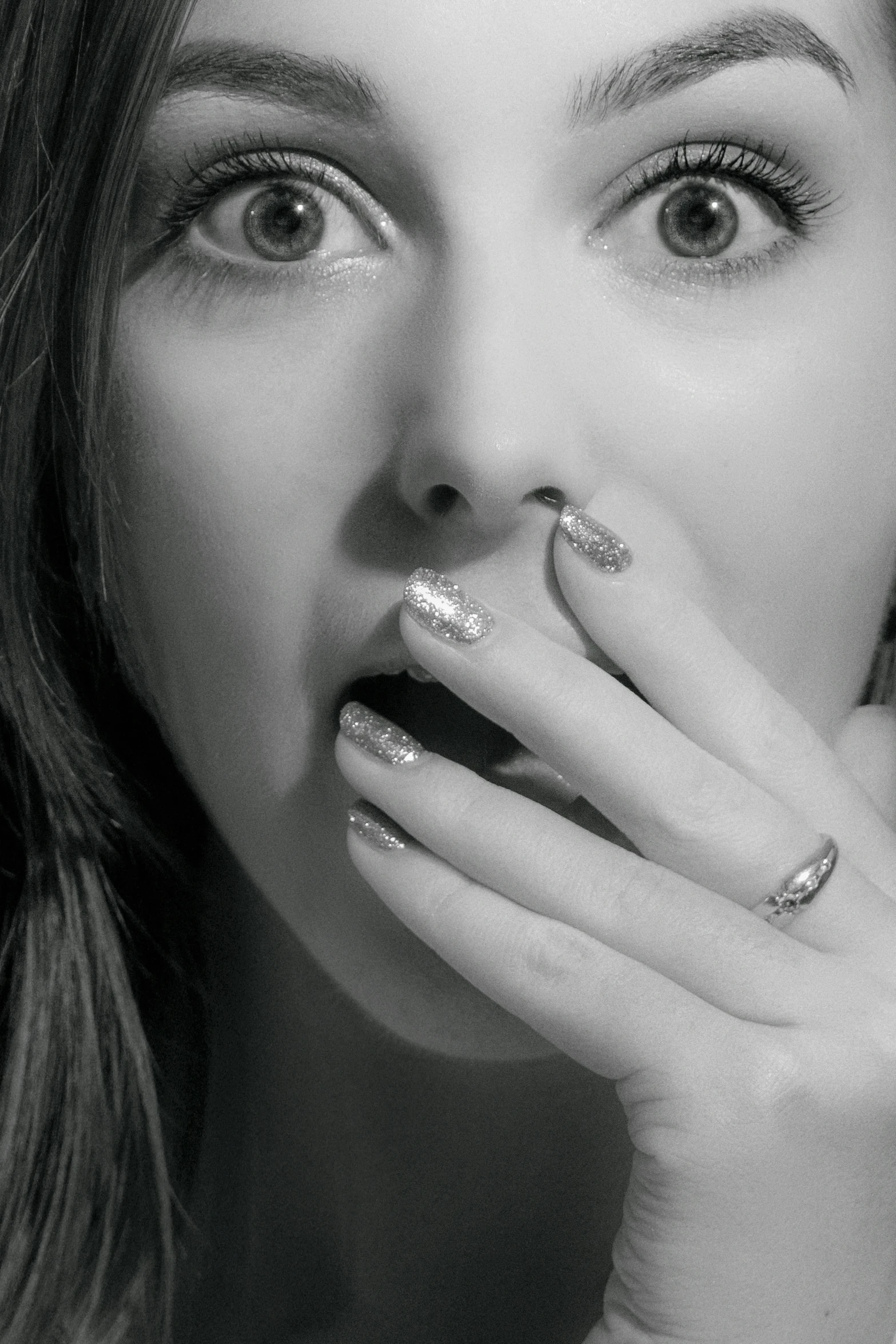 a black and white photo of a woman with a ring on her finger, inspired by Hannah Frank, performing a music video, hand over mouth, glitter gif, belle delphine