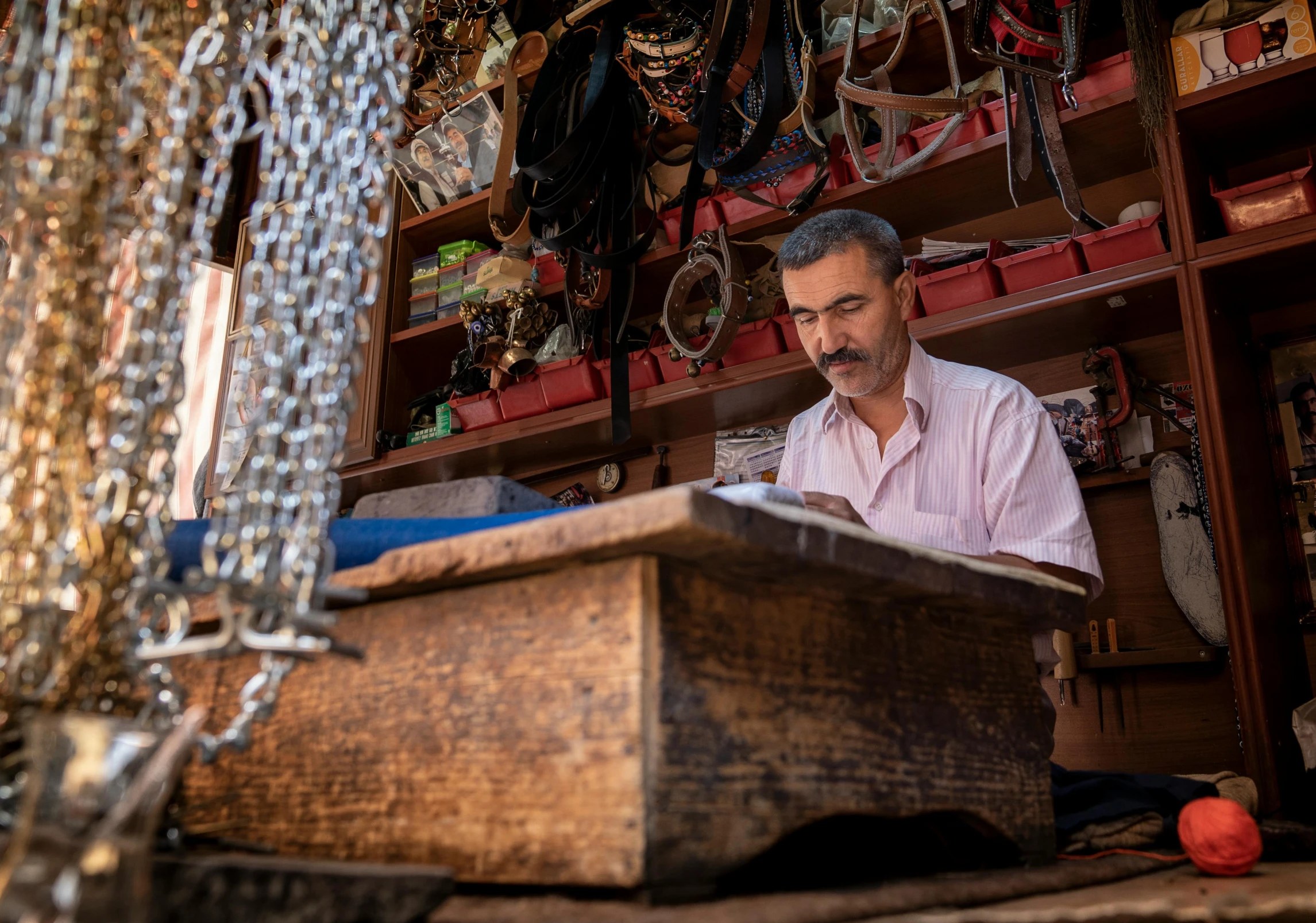 a man sitting in front of a wooden box, by Meredith Dillman, pexels contest winner, hurufiyya, market stalls, metalwork, sitting at his desk, thumbnail