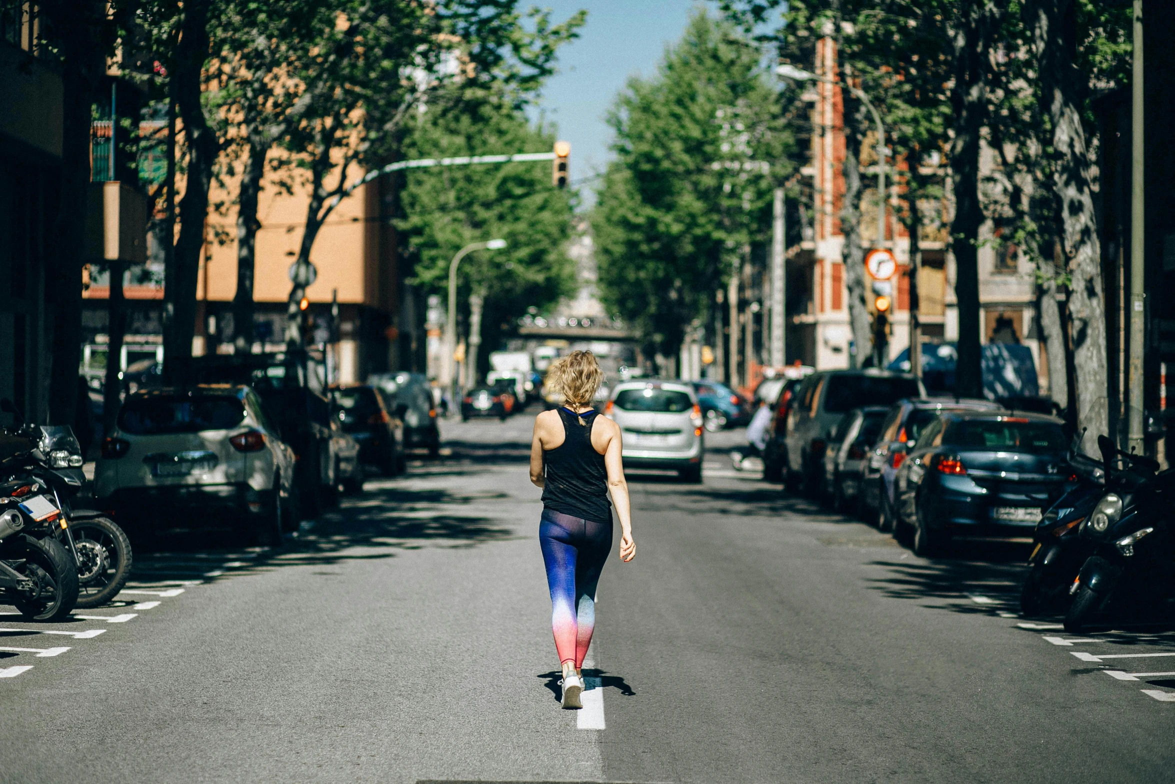 a woman riding a skateboard down the middle of a street, by Anita Malfatti, unsplash, happening, wearing fitness gear, spanish, 🚿🗝📝