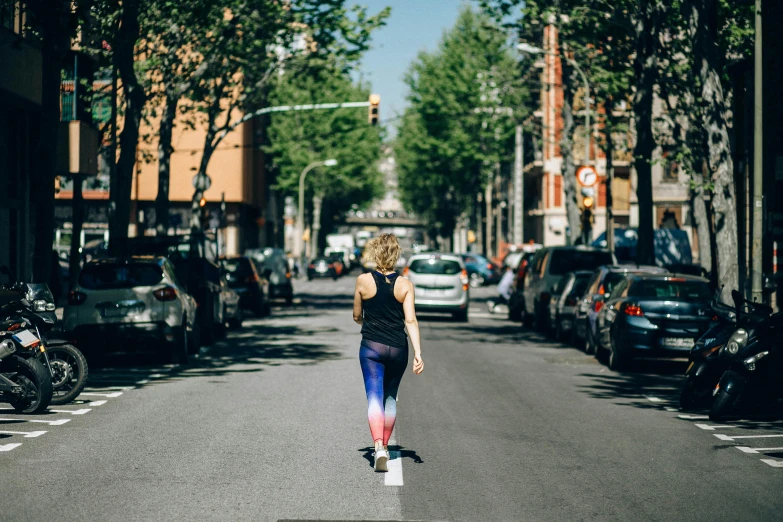 a woman riding a skateboard down the middle of a street, by Anita Malfatti, unsplash, happening, wearing fitness gear, spanish, 🚿🗝📝