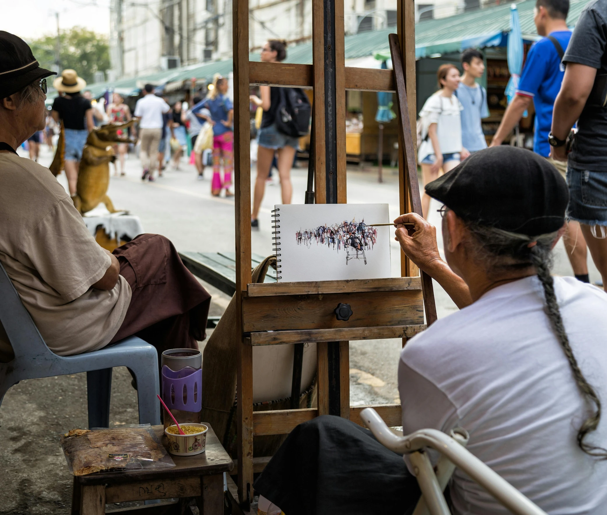 a couple of people that are sitting in front of a easel, pexels contest winner, bangkok townsquare, cuba, painting of a man, street photograph