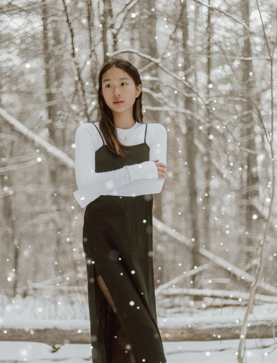 a woman standing in the snow with her arms crossed, an album cover, inspired by Itō Shinsui, trending on unsplash, renaissance, sleeveless turtleneck, wearing black camisole outfit, nico wearing a white dress, 🤤 girl portrait