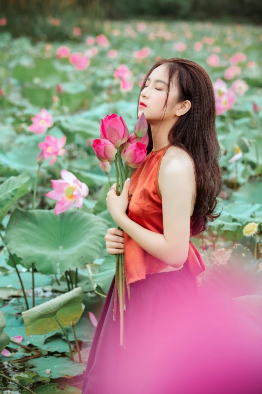 a woman standing in a field of pink flowers, an album cover, inspired by Cui Bai, nymphaea, photo 85mm, 8 k ), standing gracefully upon a lotus