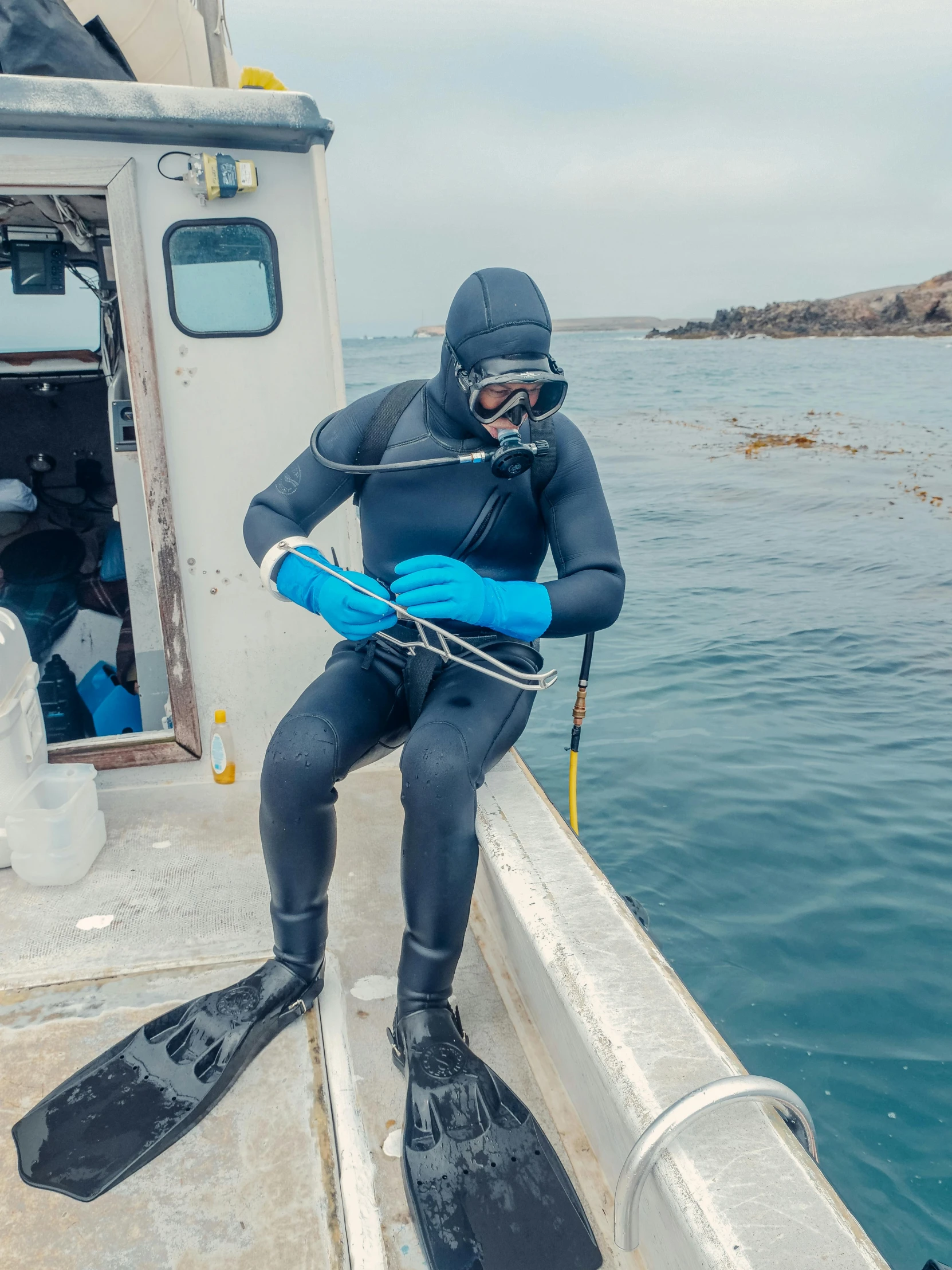 a person in a wet suit on a boat, plating, digging, in spandex suit, joongwon jeong