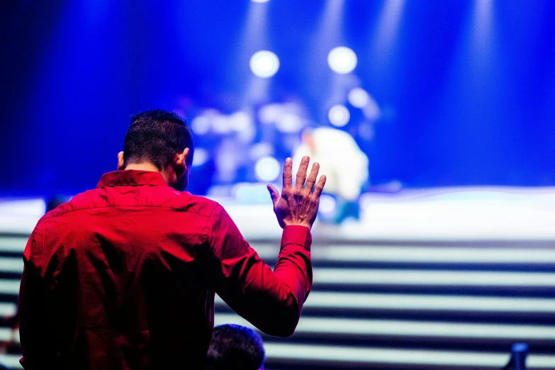 a man standing in front of a stage with his hands in the air, prayer, steps, highlights, full colour