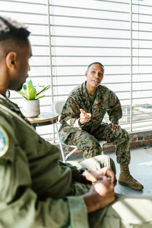 a couple of men sitting next to each other, in military uniform, talking, mental health, female