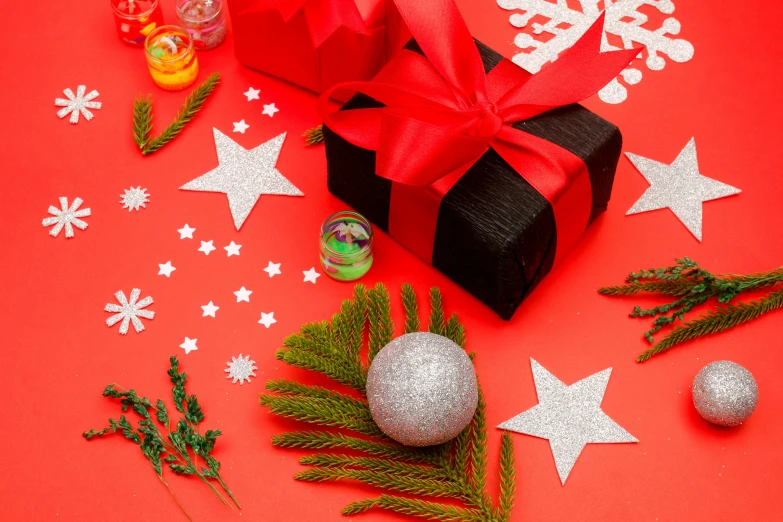 a black gift box sitting on top of a red table, by Julia Pishtar, pexels contest winner, organic ornaments, black beret with a red star, a brightly coloured, silver ornaments