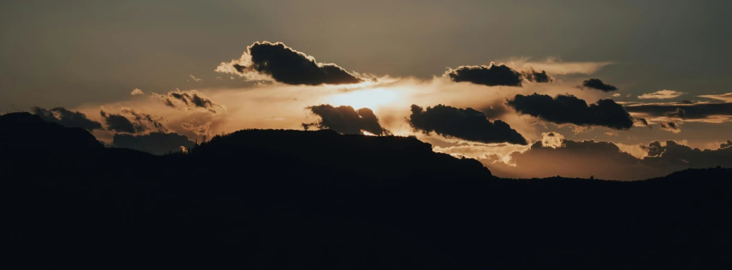 the sun is shining through the clouds over the mountains, pexels contest winner, romanticism, silhouette :7, brown, stacked image, black