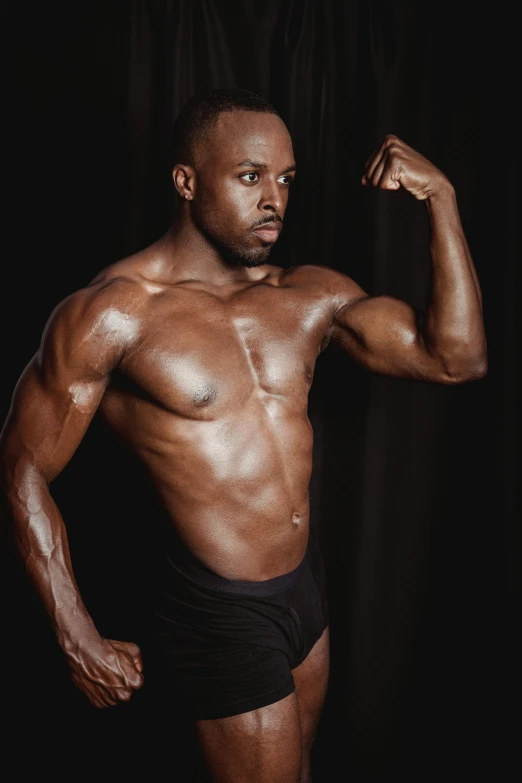 a man flexing his muscles against a black background, by Terrell James, renaissance, looking confident, kezie demessance, leaked photo, promo photo