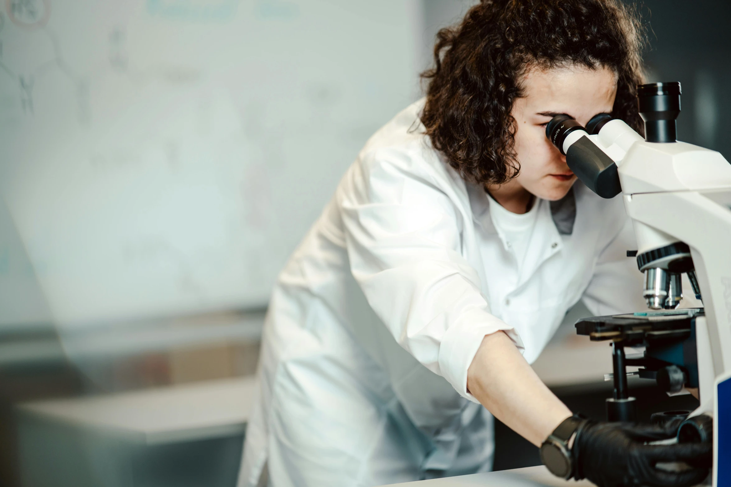 a woman in a lab coat looking through a microscope, private school, profile image, thumbnail, fan favorite