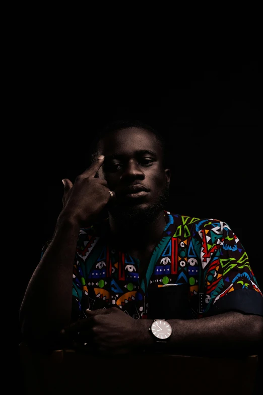 a man sitting at a table talking on a cell phone, an album cover, inspired by David Bailly, pexels contest winner, standing with a black background, hi mark ( akwaaba tommy ), arms crossed, chief keef