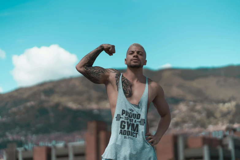 a man in a tank top posing for a picture, pexels contest winner, background image, joseph moncada, sport clothing, gang clothing