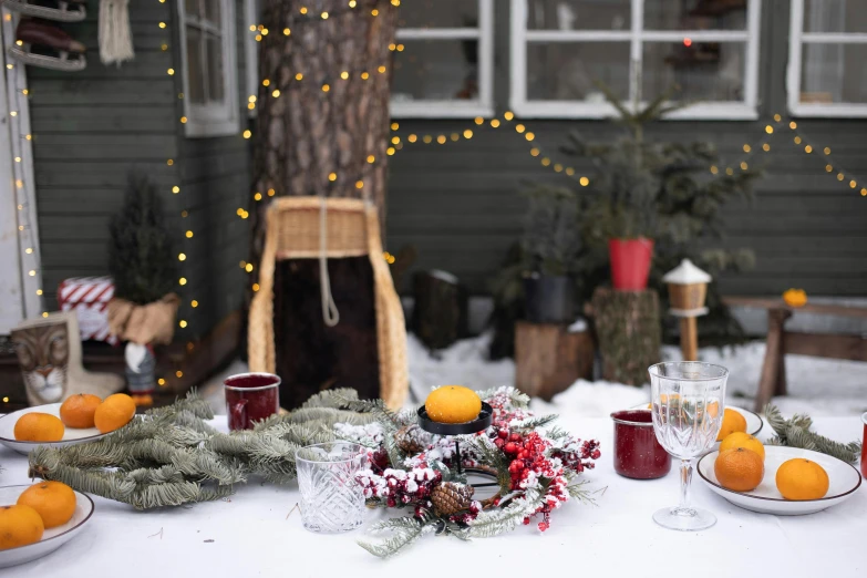 a table that has a bunch of oranges on it, inspired by Ernest William Christmas, pexels contest winner, snowing outside, ornamental halo, with snow covered colourful red, outdoor lighting