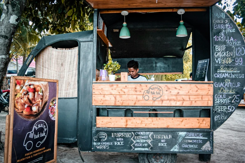 a man standing in front of a food truck, by Julia Pishtar, unsplash, a wooden, sitting down, local bar, servando lupini