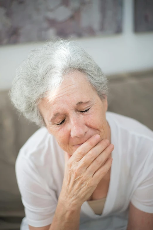 a close up of a person sitting on a couch, a picture, hard breathing, older woman, embarrassed, chiseled jaw