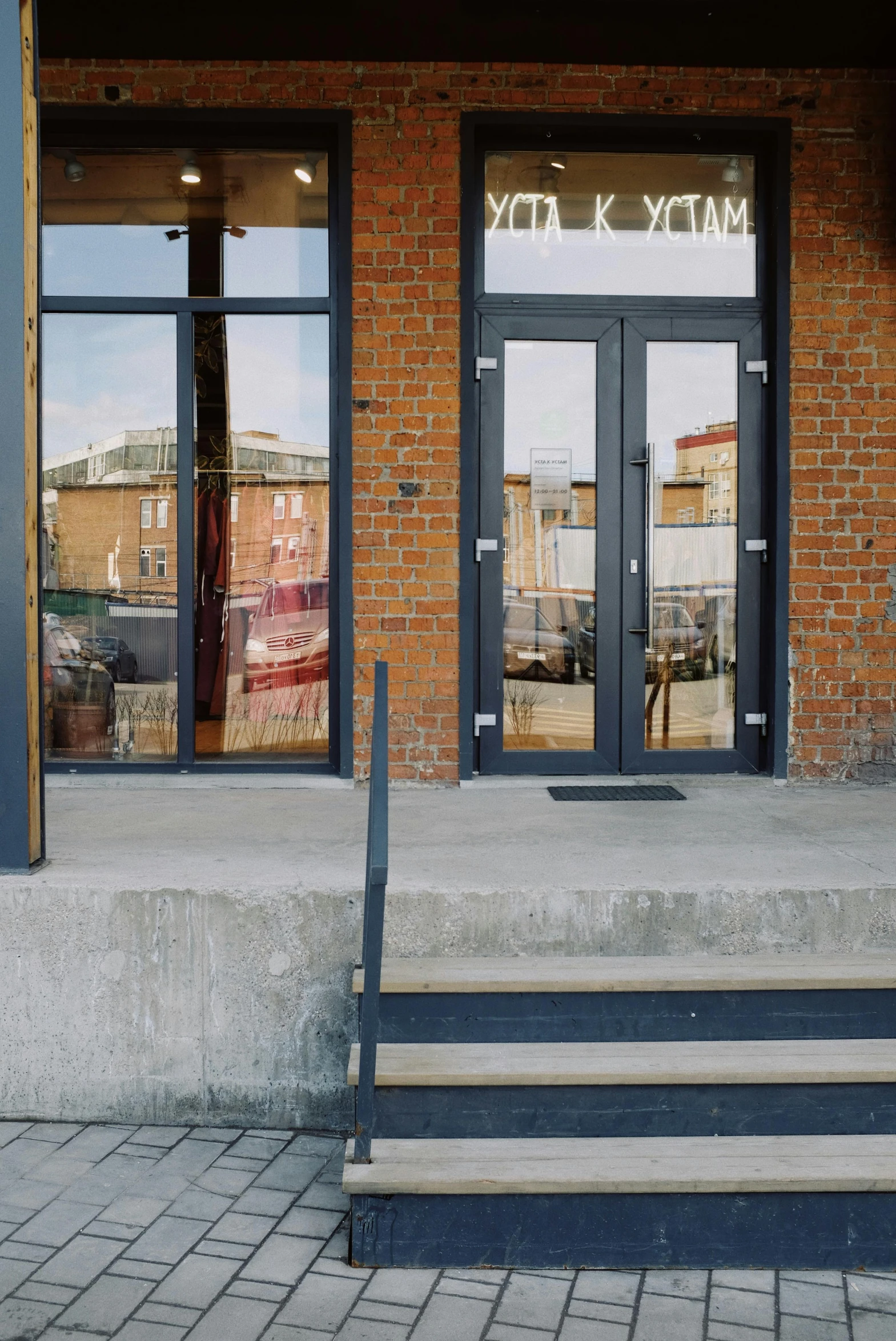 a red fire hydrant sitting in front of a building, a photo, by Nina Hamnett, modernism, doorway, bakery, slate, rear-shot