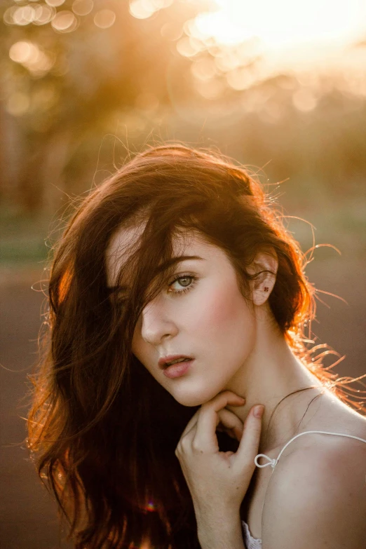a woman with long hair posing for a picture, inspired by Elsa Bleda, trending on pexels, soft golden hour lighting, pale skin!, windblown dark hair, a redheaded young woman