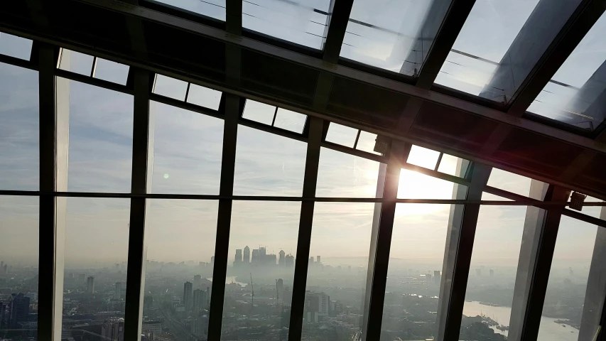 a view of a city from the top of a building, inspired by Richard Wilson, flickr, happening, huge glass structure, hazy light rays, slide show, inside a dome