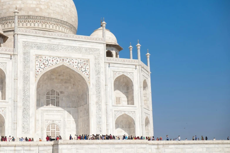 a group of people standing in front of a white building, a marble sculpture, inspired by Steve McCurry, pexels contest winner, taj mahal made of cheese, view from ground level, on a bright day, an intricate