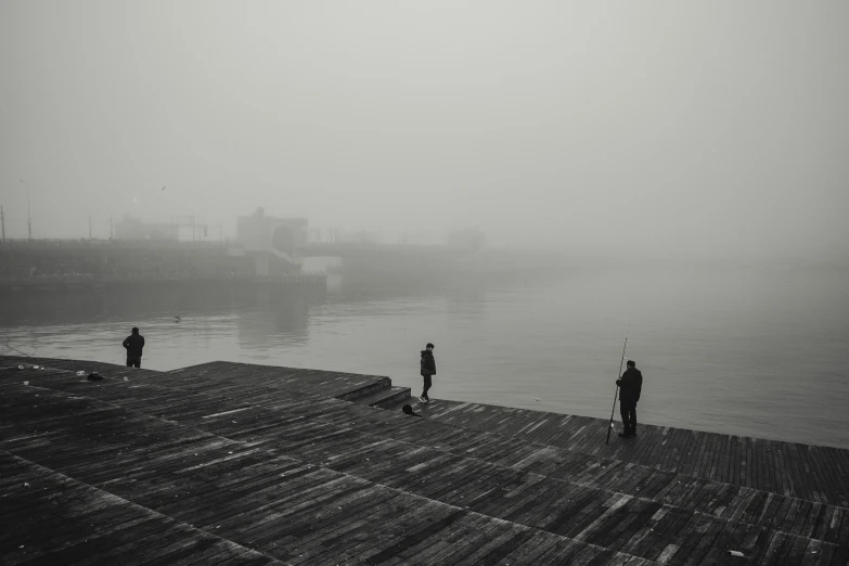 a group of people standing on a dock next to a body of water, a black and white photo, pexels contest winner, minimalism, fishing town, foggy dystopian world, harbor, foggy photo 8 k