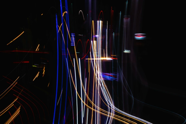 a city street filled with lots of traffic at night, inspired by Bruce Munro, unsplash, lyrical abstraction, flowing forms, vertical lines, multicoloured, sparks of light