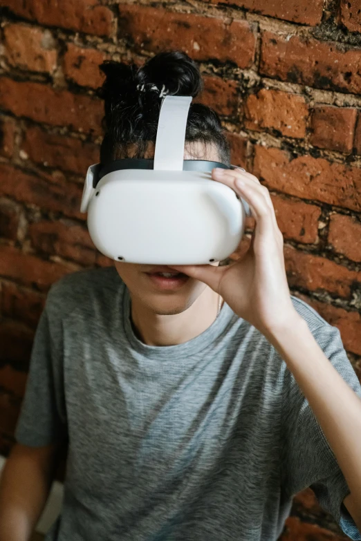 a man wearing a virtual reality headset in front of a brick wall, trending on pexels, hypermodernism, a very macular woman in white, teen boy, asian man, with unreal engine