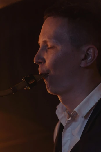 a man in a vest playing a saxophone, inspired by Jaakko Mattila, neck zoomed in, singing into microphone, torchlit, sad man
