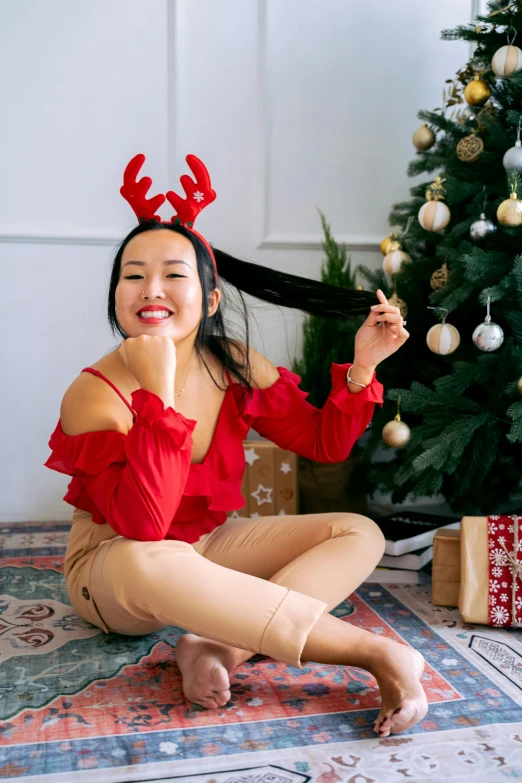 a woman sitting on the floor in front of a christmas tree, a portrait, by Julia Pishtar, pexels contest winner, big natural horns on her head, chinese girl, long black hair in a ponytail, youtube thumbnail