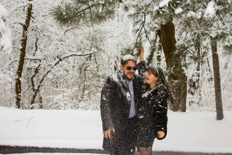 a man and a woman standing in the snow, a photo, pexels contest winner, all overly excited, trees in background, slide show, joel torres