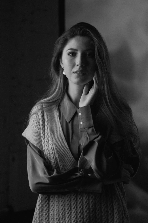 a black and white photo of a woman leaning against a wall, a black and white photo, inspired by Yousuf Karsh, trending on pexels, bae suzy, cardigan, wearing a blouse, still from a music video