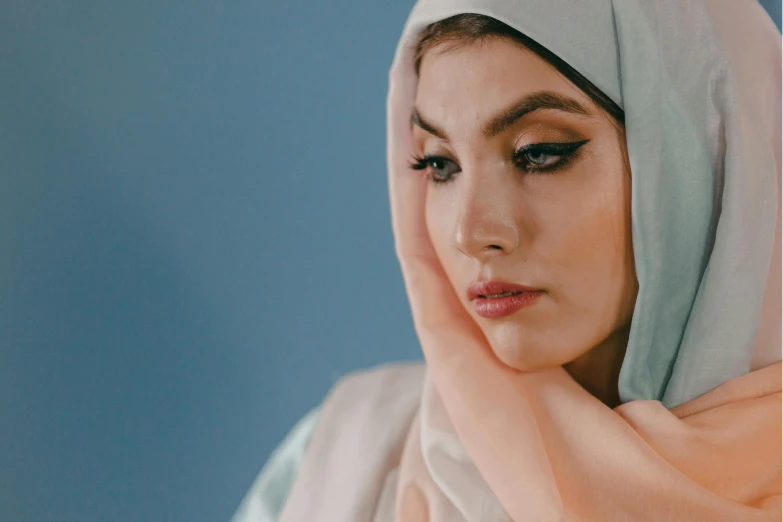 a close up of a person wearing a headscarf, trending on pexels, hurufiyya, pale bluish skin, attractive face and body, asian female, stylised