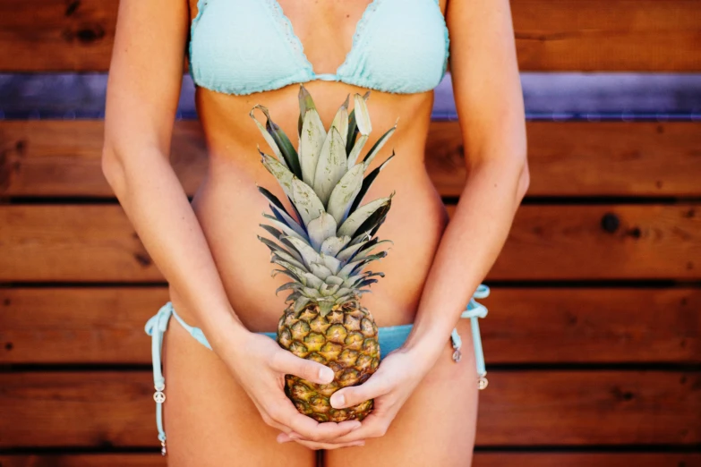 a woman in a bikini holding a pineapple, unsplash, fine art, anatomically incorrect, physical : tinyest midriff ever, pregnancy, venus effect